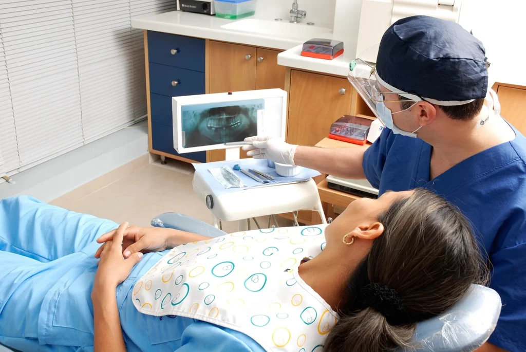 Dentista apresentando radiografia panoramica a paciente no consultorio