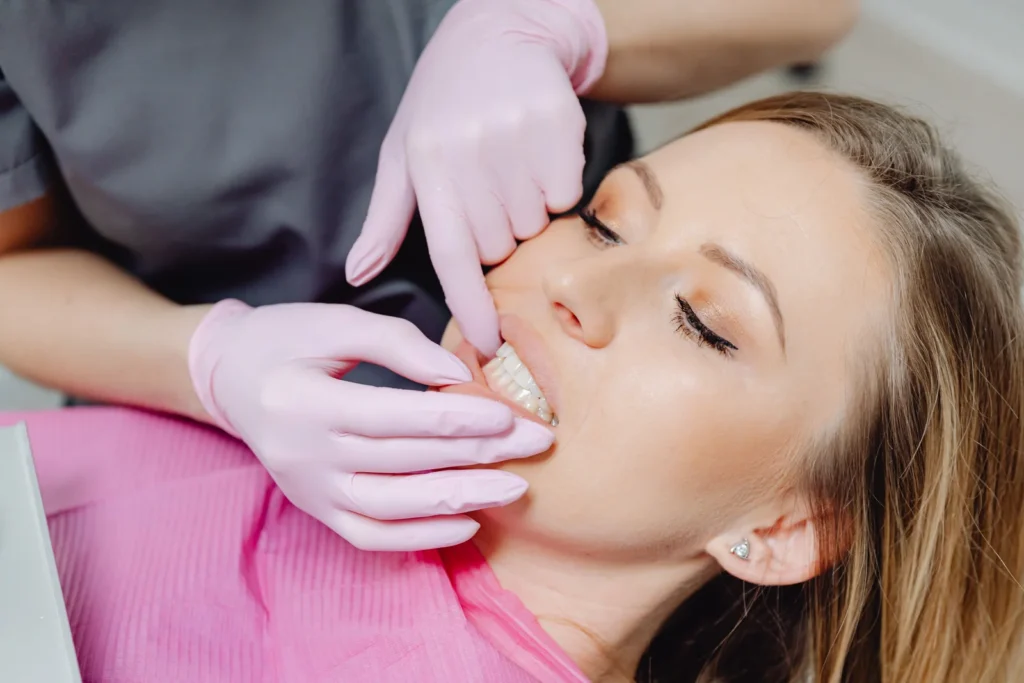 Dentista examinando a regiao da face e do ouvido de uma paciente