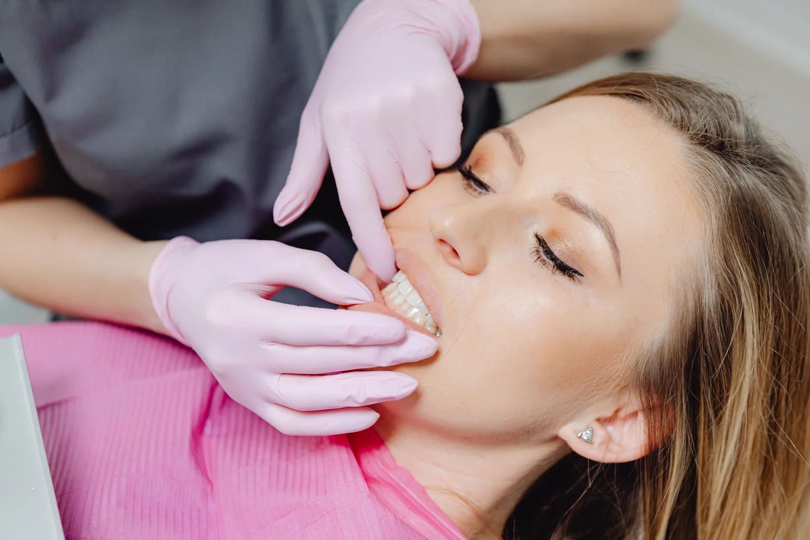 Dentista examinando a regiao da face e do ouvido de uma paciente