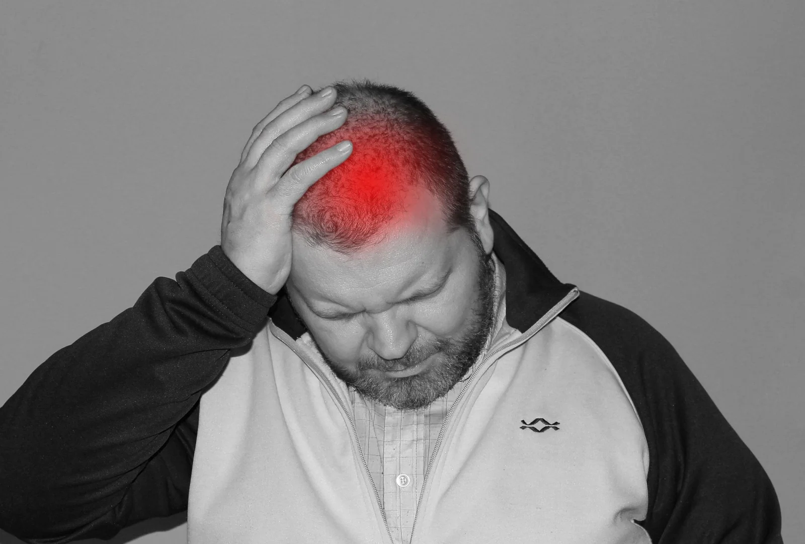 Homem com dor de cabeca destacada em vermelho na regiao frontal