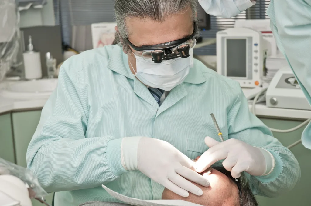 Cirurgiao-dentista realizando exame clinico da boca de um paciente