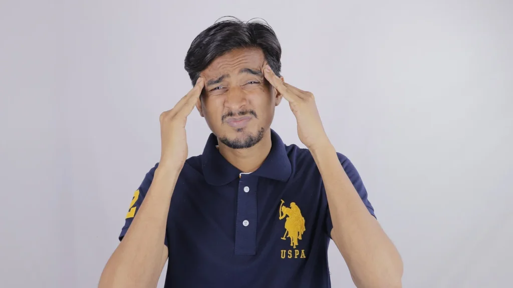 Homem pressionando as temporas com os dedos por tensao muscular